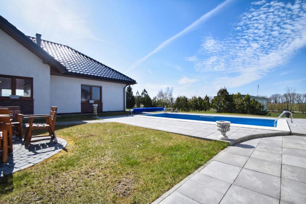 a backyard with a swimming pool and a house at Willa u Hanysa in Niechorze