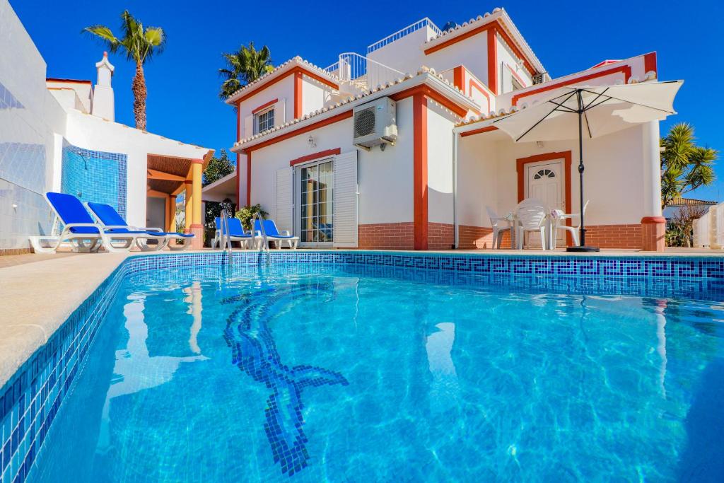 a villa with a swimming pool in front of a house at Cantinho do Mocho in Pêra