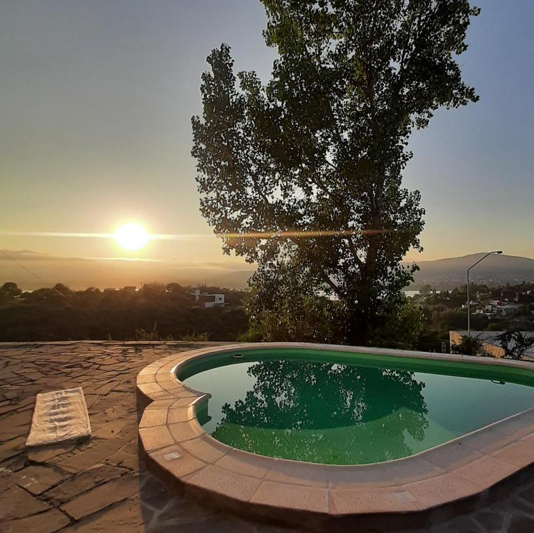 una piscina con puesta de sol en el fondo en Mediterránea Casa Vacanza en Villa Carlos Paz