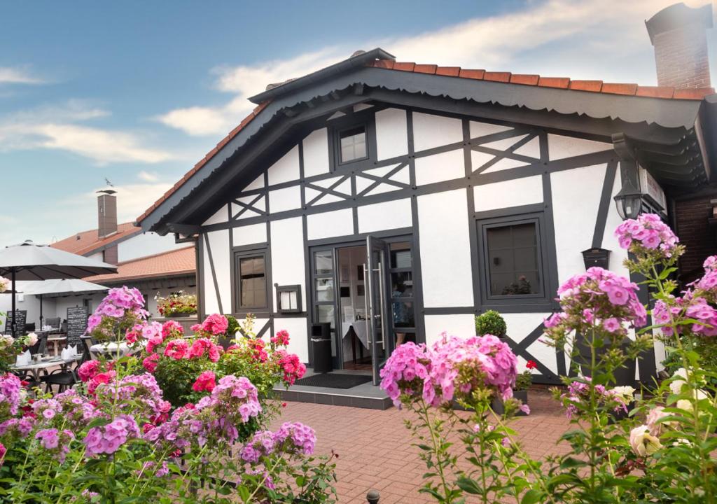 ein Haus mit rosa Blumen davor in der Unterkunft Hotel Rosenhof GmbH in Ramstein-Miesenbach