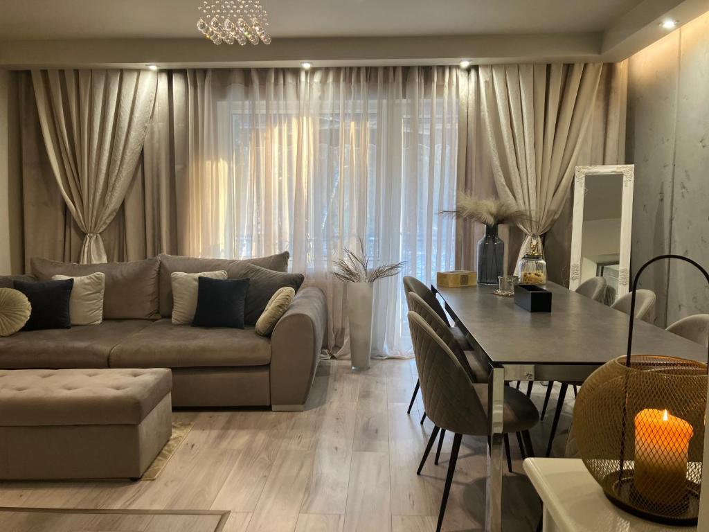 uma sala de estar com um sofá e uma mesa em Apartamenty Arkadia em Mrągowo