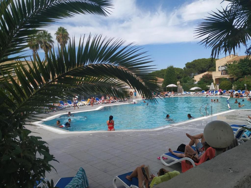 uma grande piscina com pessoas num resort em Résidence Odalys Saint Loup Appartement Climatisé entierement rénové em Cap d'Agde