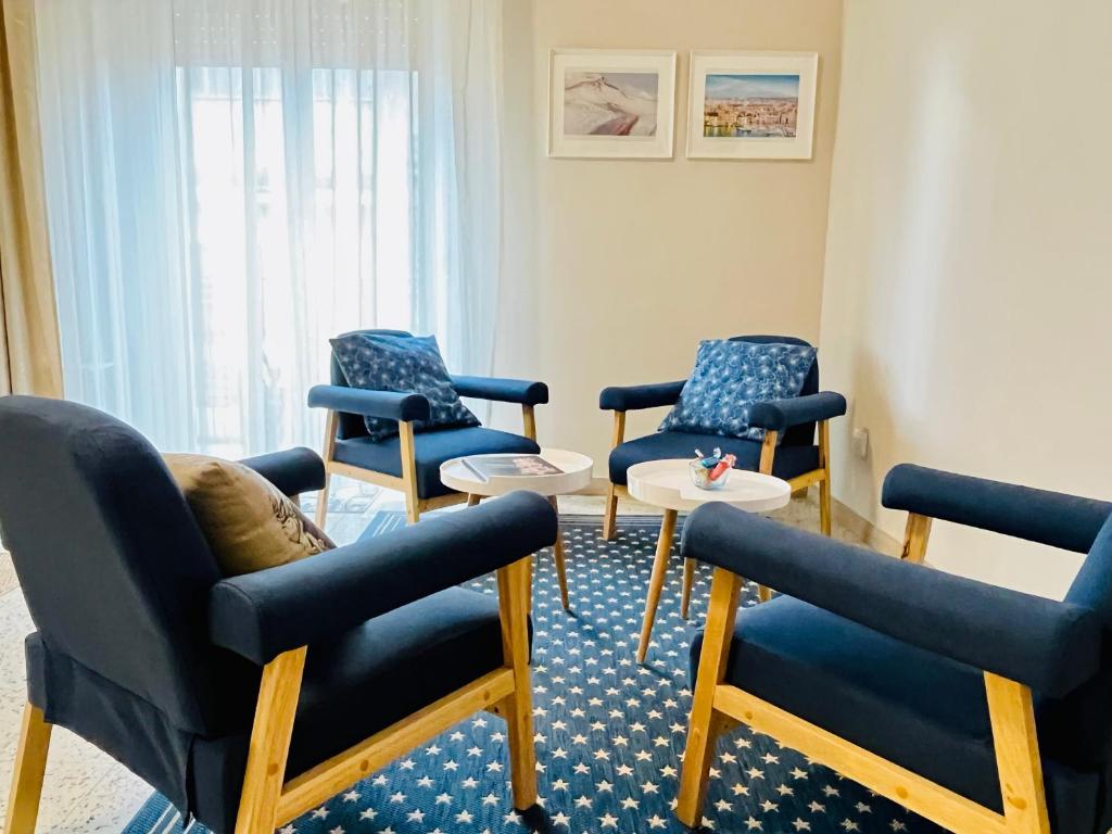 - une salle d'attente avec des chaises bleues et une table dans l'établissement Mita Apartments, à Catane