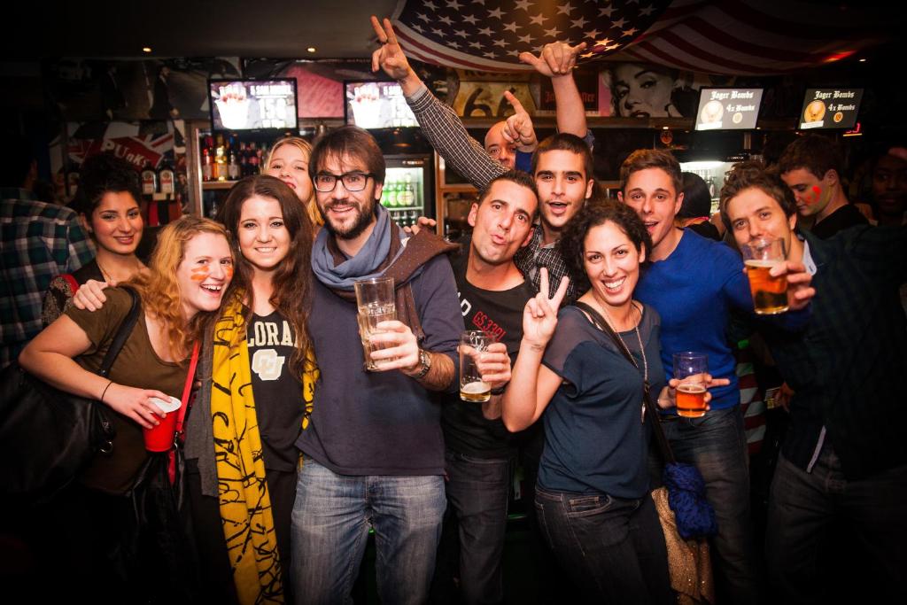 a group of people posing for a picture in a bar at St Christopher's Inn Paris - Canal in Paris