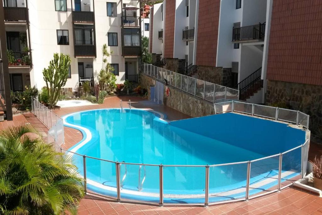 a large blue swimming pool in the middle of a building at Casa Alisios in Playa de Santiago