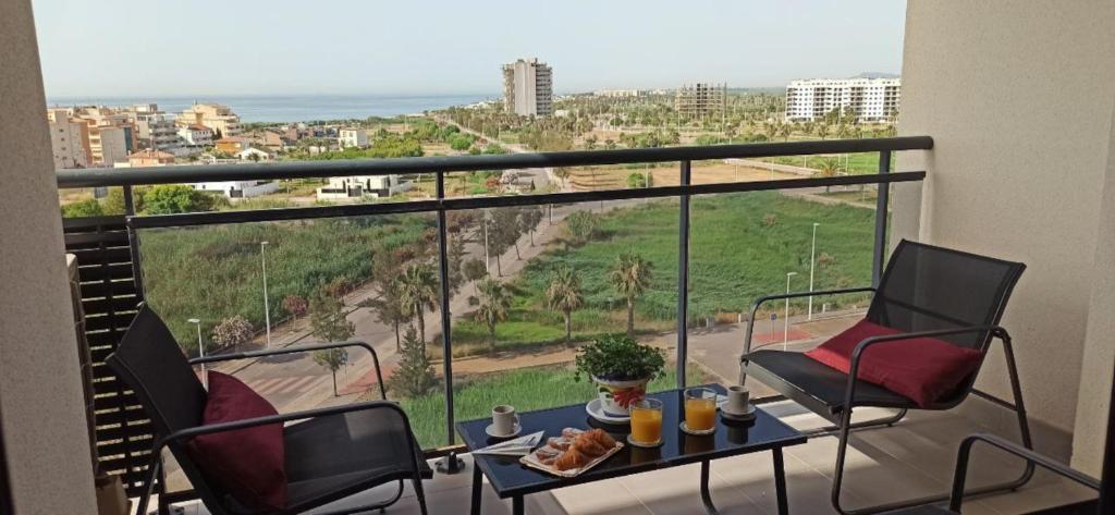 een balkon met een tafel en stoelen en uitzicht op de oceaan bij Apartamento Aguamarina - Playa Moncofa in Moncófar