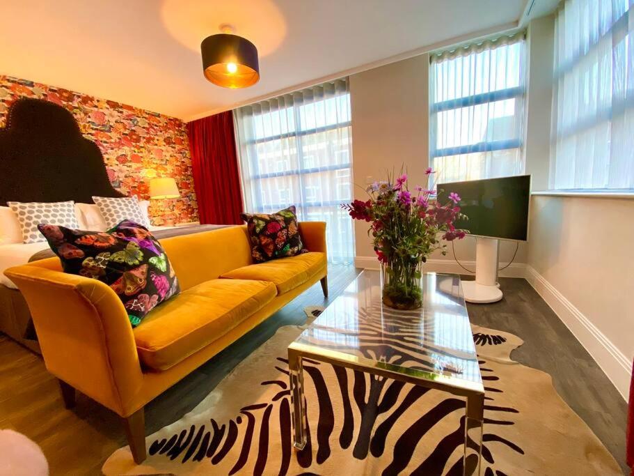 a living room with a couch and a table at Luxurious Studio Apartment - 1 Minute walk to Poole Quay - Great Location - Free Parking - Fast WiFi - Smart TV - Newly decorated - sleeps up to 2! Close to Poole & Bournemouth & Sandbanks in Poole