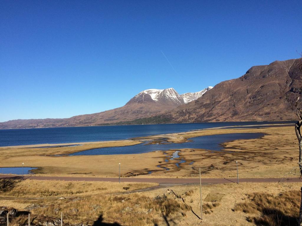 a view of a lake with mountains in the background at Ferroch the place with an amazing view! in Torridon