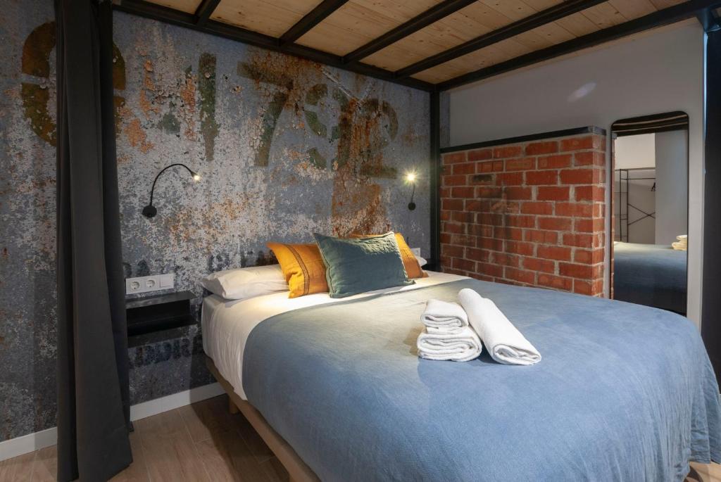 a bedroom with a large bed with towels on it at Loft con carácter en Valencia. in Valencia