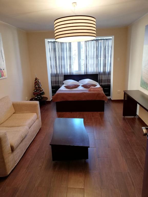 a living room with a bed and a couch at APARTAMENT AUTENTIC RESIDENCE in Predeal