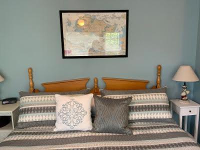1 dormitorio con 1 cama con almohadas y un mapa en la pared en Chateau Country Inn and Captain's Cottage, en Clayton