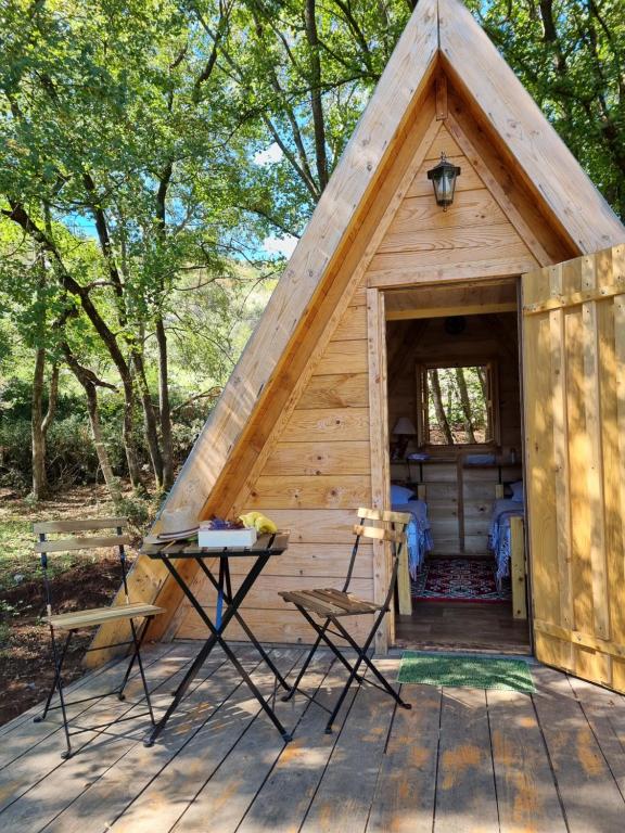 uma pequena cabina de madeira com um telhado inclinado em Wolf & Sheep Nature & Adventure em Podgorica