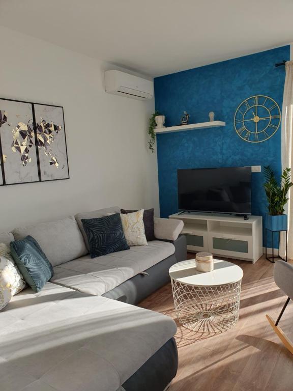 a living room with a couch and a tv at Apartment Marlena in Mokošica
