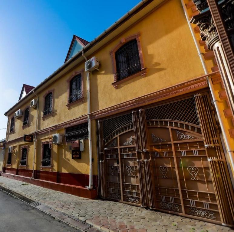 un bâtiment avec deux portes de garage dans une rue dans l'établissement ALI HOSTEL, à Douchanbé