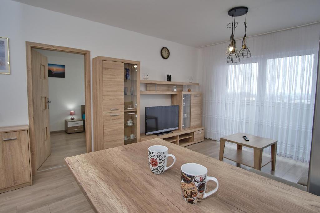 a living room with two coffee mugs on a table at Apartament Słoneczny 11 in Opole