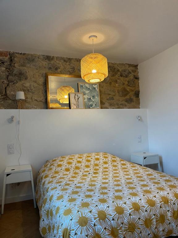 een slaapkamer met een bed met een gele en witte sprei bij Appartement T2 in Salles-la-Source