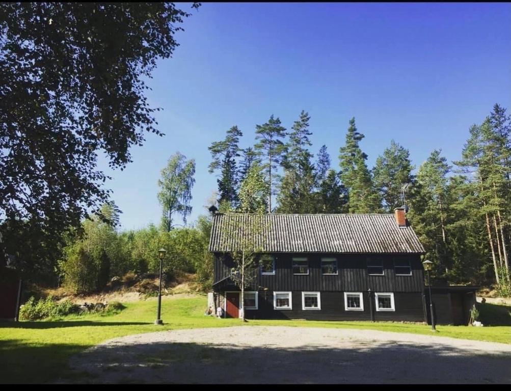 a black house in the middle of a field at Tosthult Holiday 2 in Lönsboda