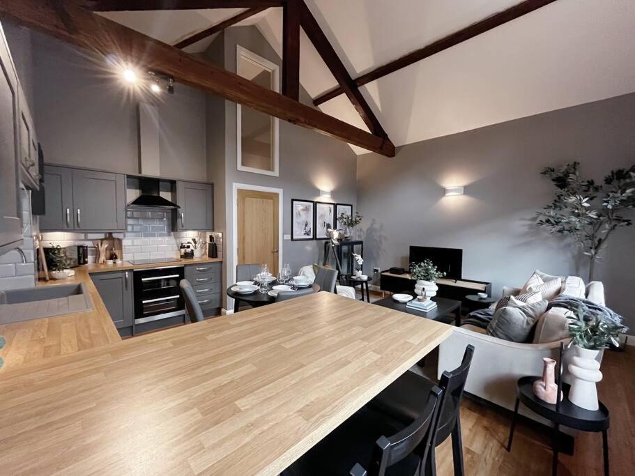 a kitchen and living room with a large wooden table at Cosy 2 Bedroom Apartment in Todmorden