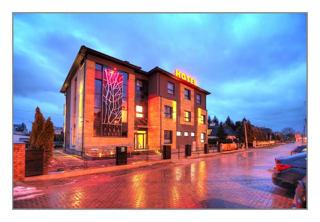 a building with a neon sign on it on a street at Villa Park in Siedlce