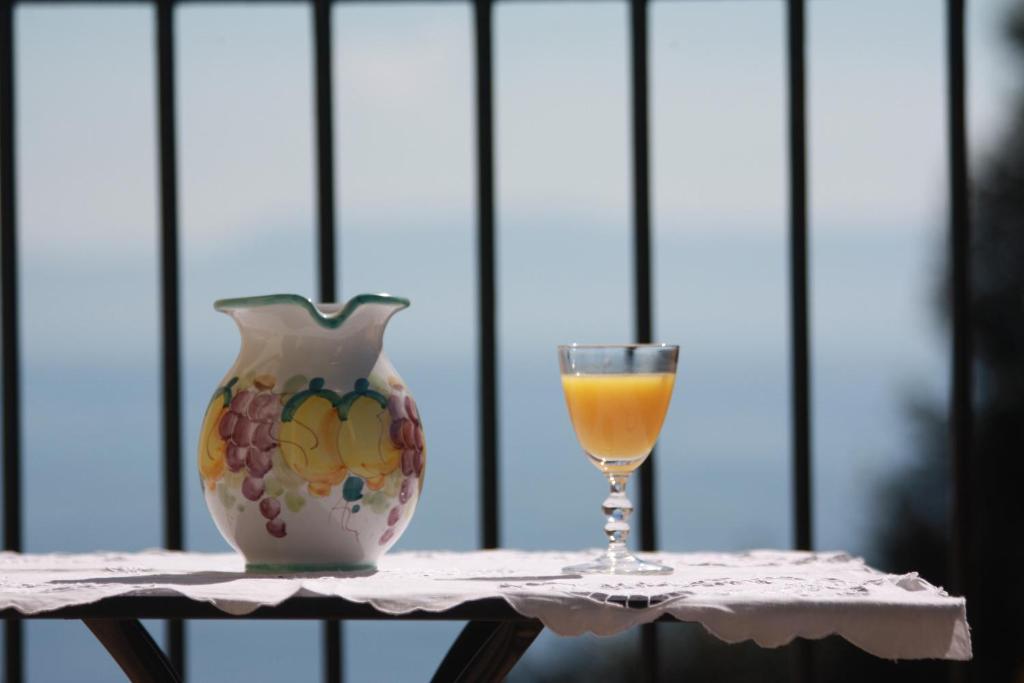 ナポリにあるCasetta Belvedereの花瓶とオレンジジュース1杯