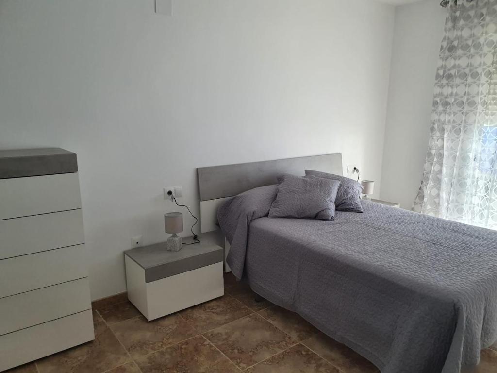 a white bedroom with a bed and a dresser at Nuevo Jerez in Jerez de la Frontera