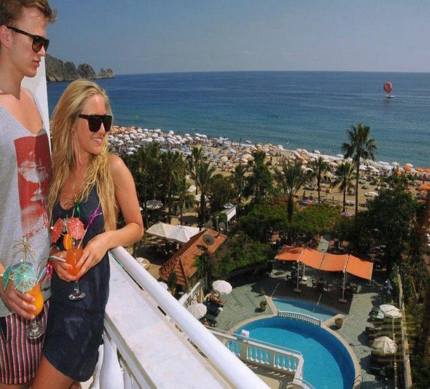 a man and a woman standing on the balcony of a resort at Azak Hotel in Alanya