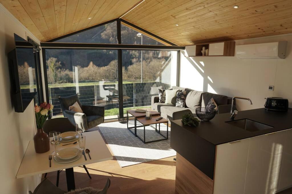 uma cozinha e uma sala de estar com uma grande janela em Velo & Wohnen -NEU- Elektroräder inklusive-Sauna-Moselblick em Enkirch