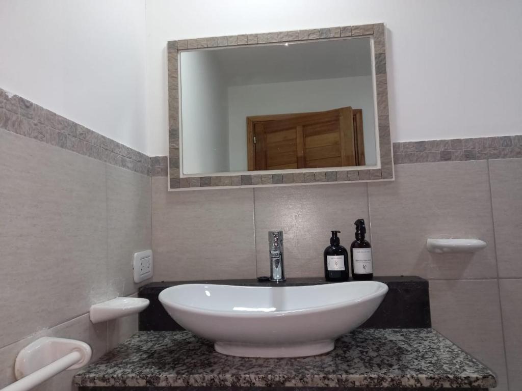 a bathroom with a sink and two bottles of wine at Casa Nera in Esquel