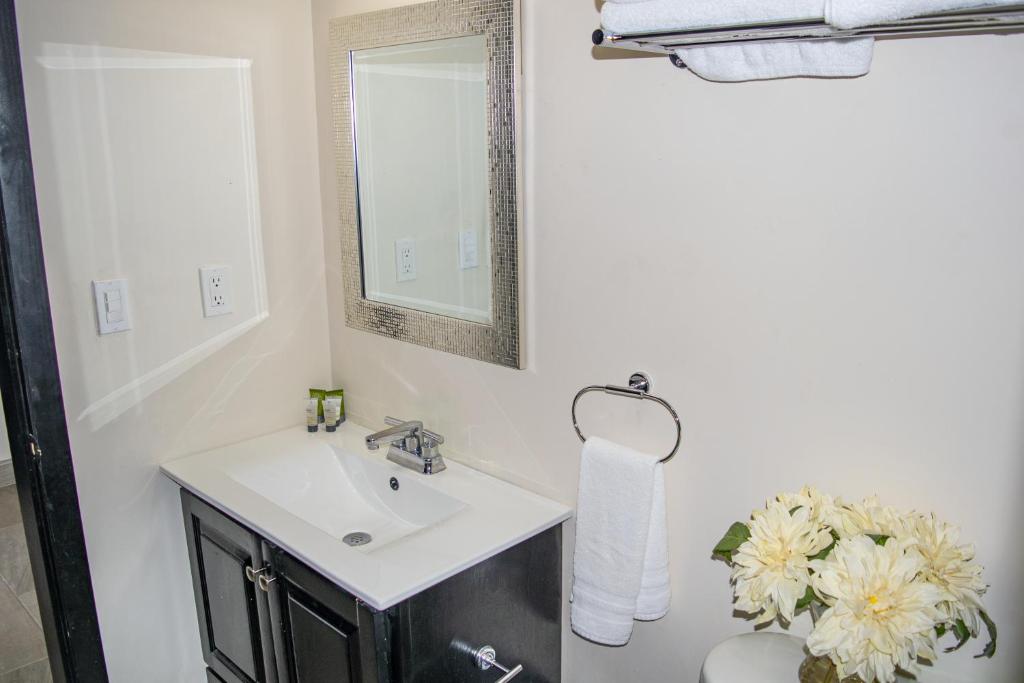 a white bathroom with a sink and a mirror at Playas Hotel Suites in Puerto Peñasco