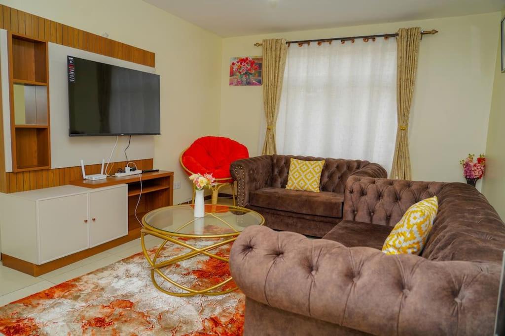 Sala de estar con 2 sofás y TV en Havan Furnished Apartments-Milimani N8 en Nakuru