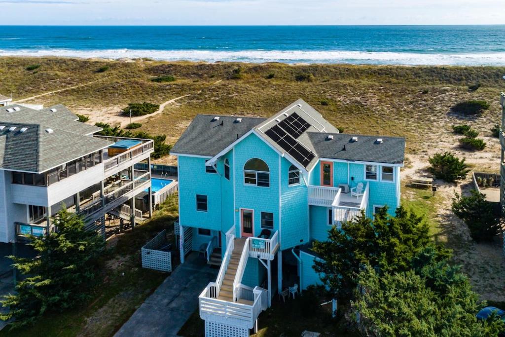 - une vue aérienne sur une maison bleue sur la plage dans l'établissement Looney Dunes, à Waves