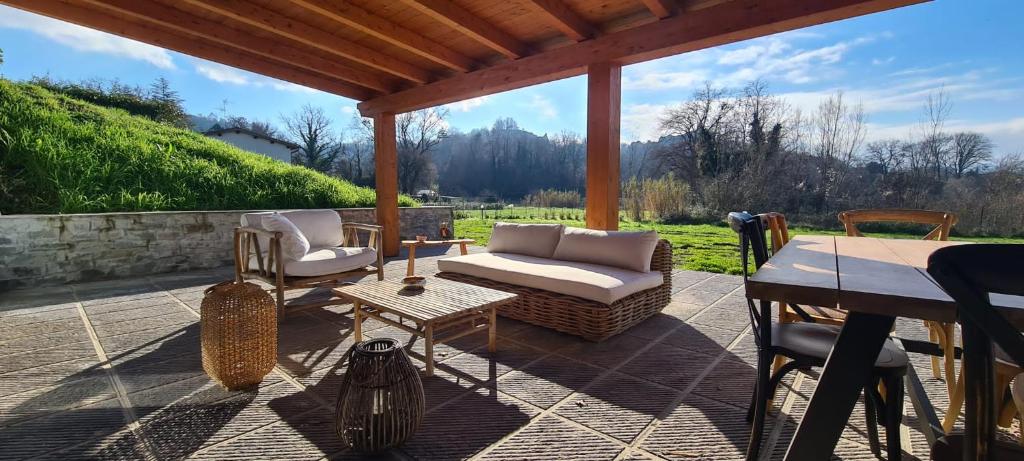 un patio con sofá, sillas y mesa en Villa Azzurra immersa nel Verde tra Firenze, Arezzo e Siena, en Terranuova Bracciolini