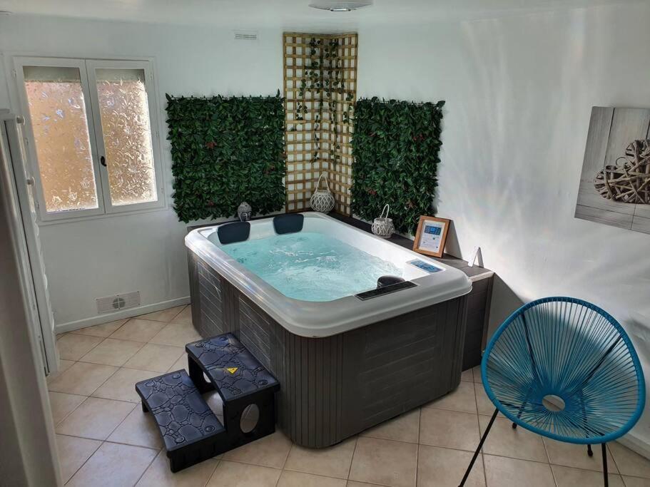 埃奇昂普拉奇的住宿－Maison avec Jacuzzi privatif et terrasse N’1，一个带风扇的客房内的大型热水浴缸