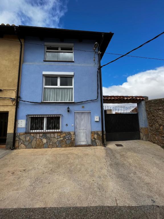 a blue house with a driveway in front of it at Casa Rural Maroto in Campillo