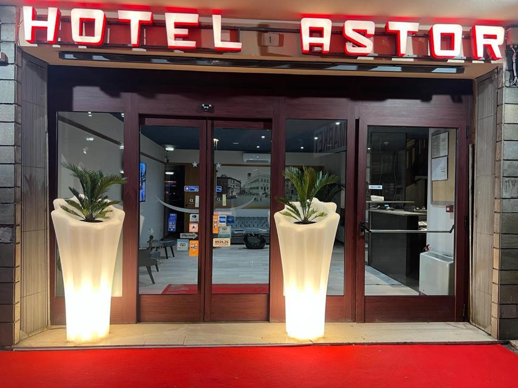 a hotel entrance with two large vases in front of it at Hotel Astor in Perugia