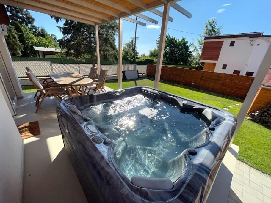 a hot tub on a patio with a table at Felix House Siófok in Siófok