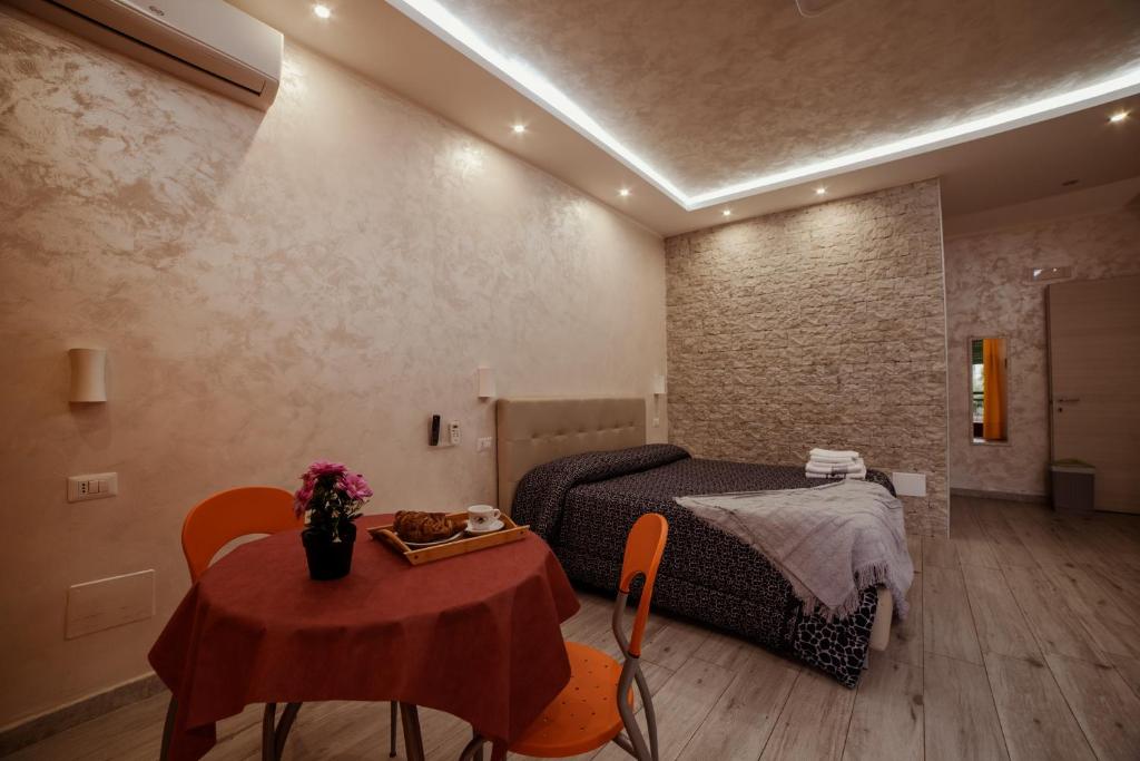 une chambre d'hôtel avec un lit, une table, une table et des chaises dans l'établissement B&B La Colonna, à Crotone