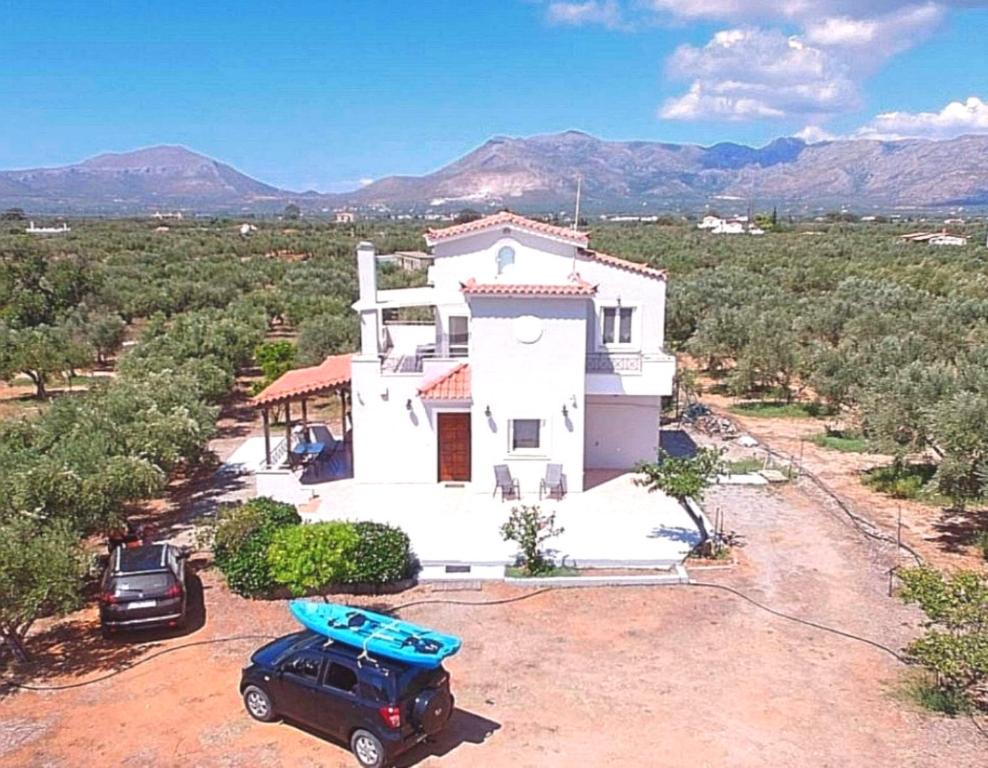 un coche aparcado frente a una casa con una tabla de surf en Olive Tree House I, 