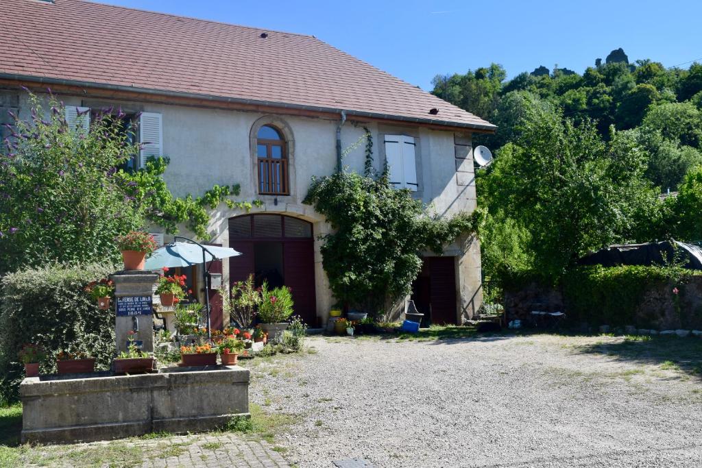 una casa con muchas plantas delante de ella en Spacious apartment in old farm close to Lac de Vouglans en La Tour-du-Meix