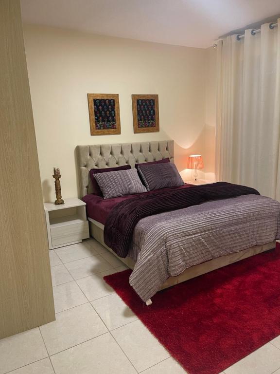 a bedroom with a large bed with a red rug at Beautifull New 2 Bedroom Apartment in Amman in Amman