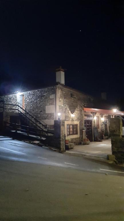 a stone building with lights on it at night at Ferradosa GuestHouse in Vale de Figueira
