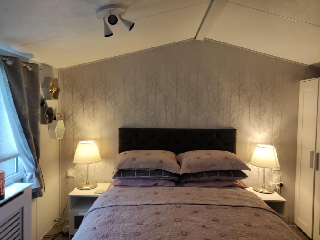 una camera con un grande letto con due lampade di "Dew Drop Inn" a Port Seton