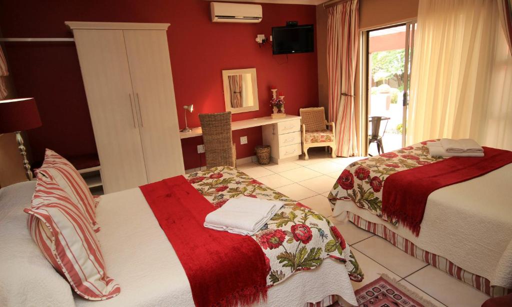 Avalon Guest Manor في نيوكاسل: غرفة نوم بسريرين ومكتب مع مرآة