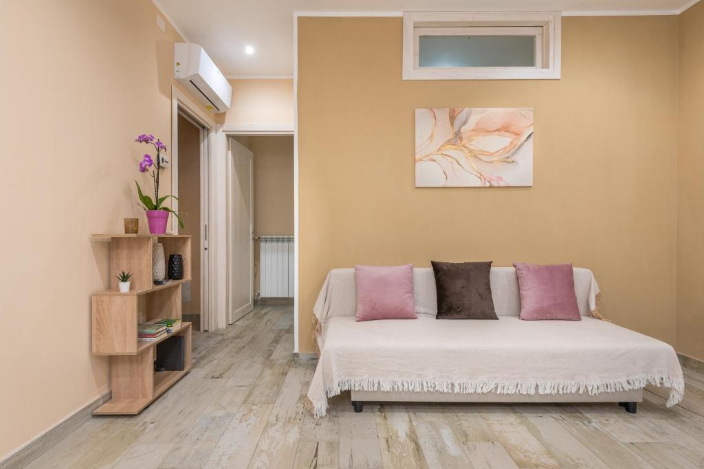 a bedroom with a bed with pink pillows on it at Good Time Apartment in Ciampino