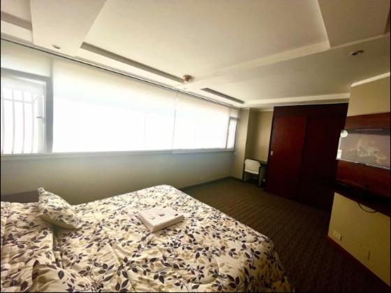 Una habitación de hotel con una cama con una bandeja. en 1420 Lujosa Habitación - Hotel Akros, en Quito