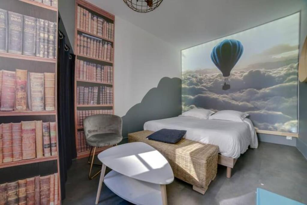 - une chambre avec un lit orné d'une grande peinture de montgolfière dans l'établissement La tête dans les nuages, à Rouen