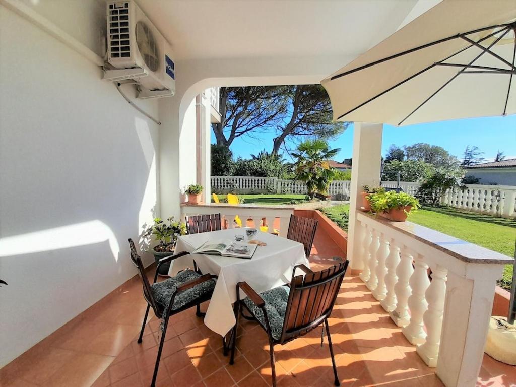 a patio with a table and chairs and an umbrella at Romantic Apartment Anna in the center of Krk in Krk