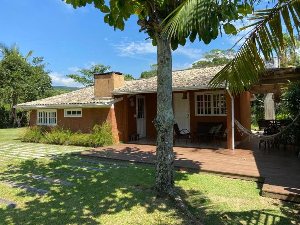 a house with a hammock in front of it at Morada dos Coqueiros in Garopaba