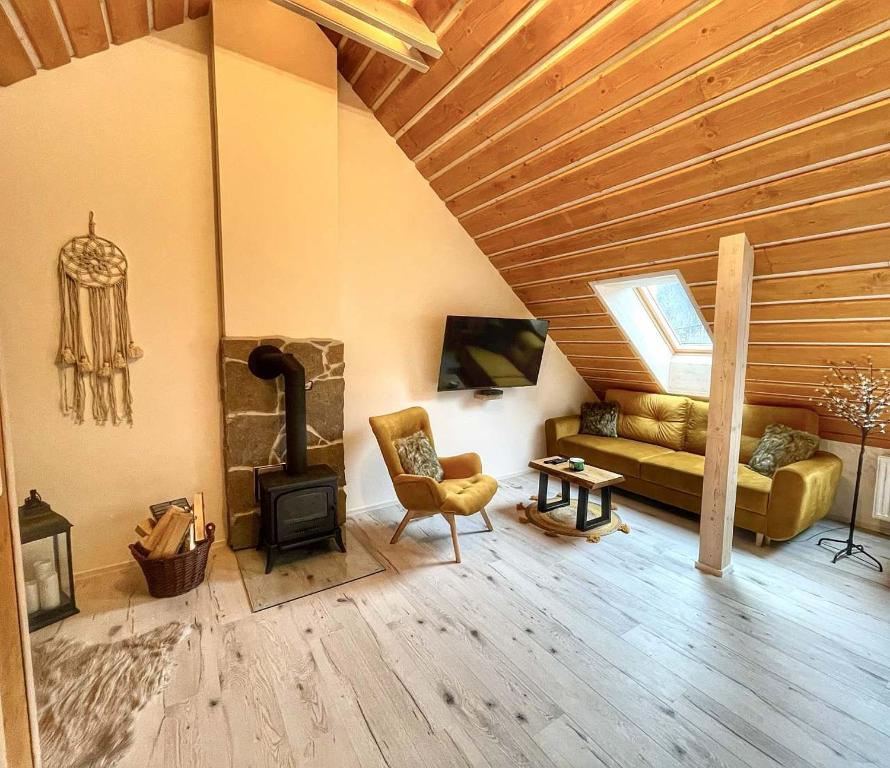 sala de estar con sofá y estufa de leña en Vantova Chalupa, en Ludvíkov