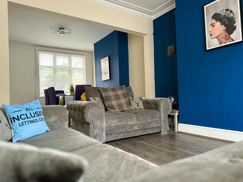 a living room with two couches and a blue wall at Whitworth House, Sleeps 6 TVs in all bedrooms, WIFI - 3 bedroom in Northampton